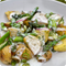 Sommersalat mit Kartoffeln, Spargel, Radieschen und Dill in einer cremigen Sauce auf einem weißen Teller.