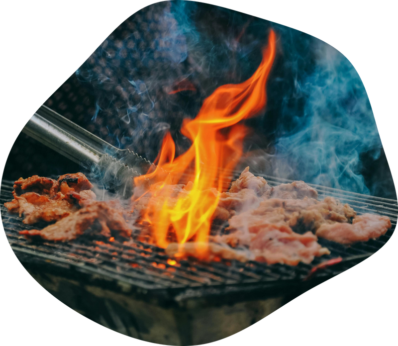 Fleischstücke werden mit einer Grillzange auf eine
